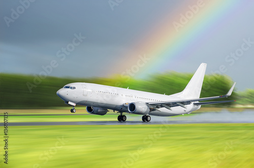 Airplane Airport take off in the rain on a background a rainbow