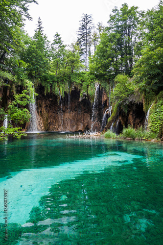 Waterfall flowing into the forest lake. Plitvice, National Park, © Andrii Zastrozhnov