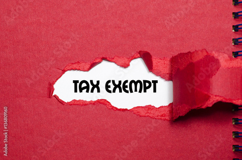 The word tax exempt appearing behind torn paper
