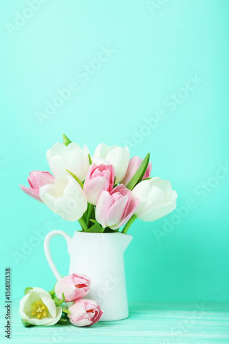 Fototapeta Naklejka Na Ścianę i Meble -  Bouquet of tulips in jug on green background