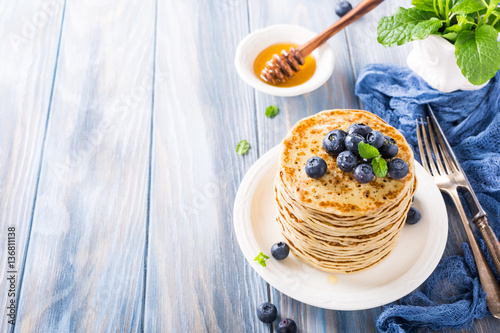 Delicious pancakes with fresh blueberries on a wooden background. Healthy breakfast concept with copy space.
