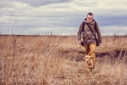 Hiker and dog in grassland © kerkezz