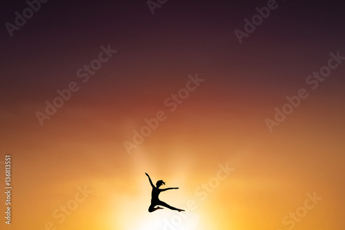 Carefree woman leaps at dusk time