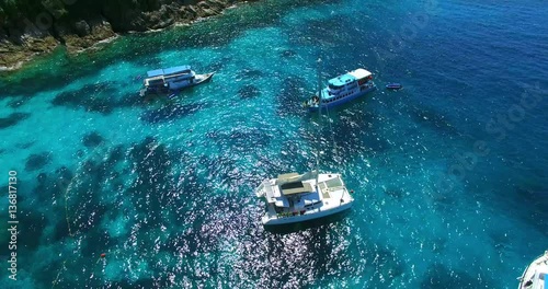 Racha Island Beach. Thailand, Phuket. Yachts , Catamarans and Boats sailing in crrystal clear blue water of ocean. Take off from ocean to sky. Aerial view. 4K. photo