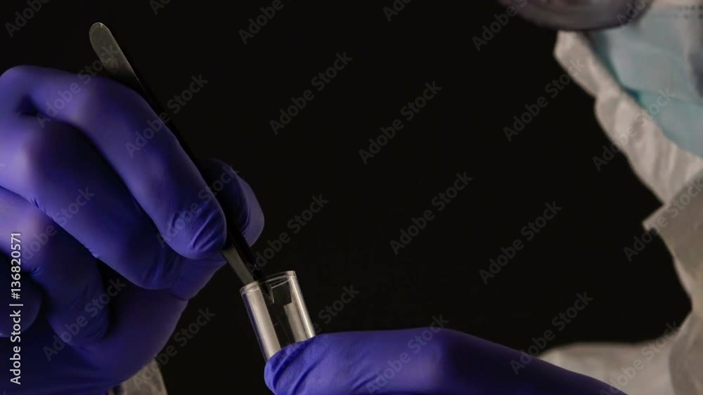 Forensic scientist putting hair in evidence tube during crime scene investigation