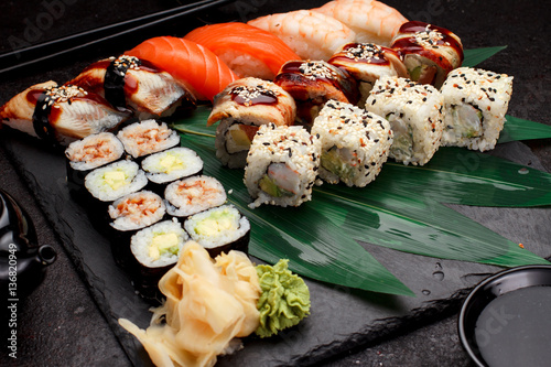 Japanese cuisine. Sushi set on a stone plate and dark concrete background