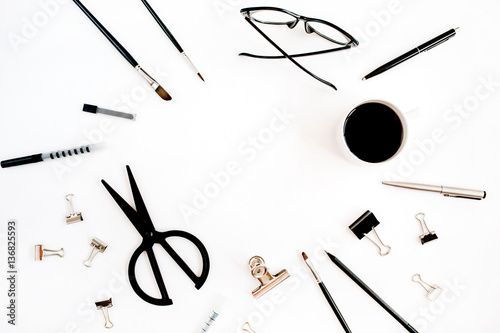 White office desk frame with supplies. Coffee, scissors, pen, clips, glasses and office supplies on white background. Flat lay, top view office table desk.