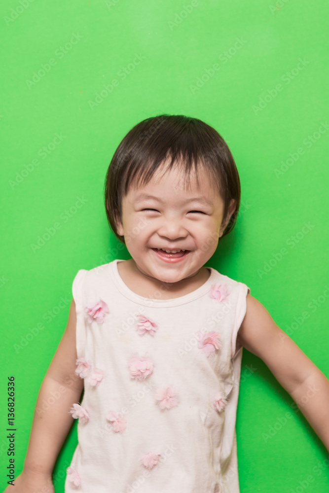 Happy asian girl smiling on green background Happy asian girl smiling on green background