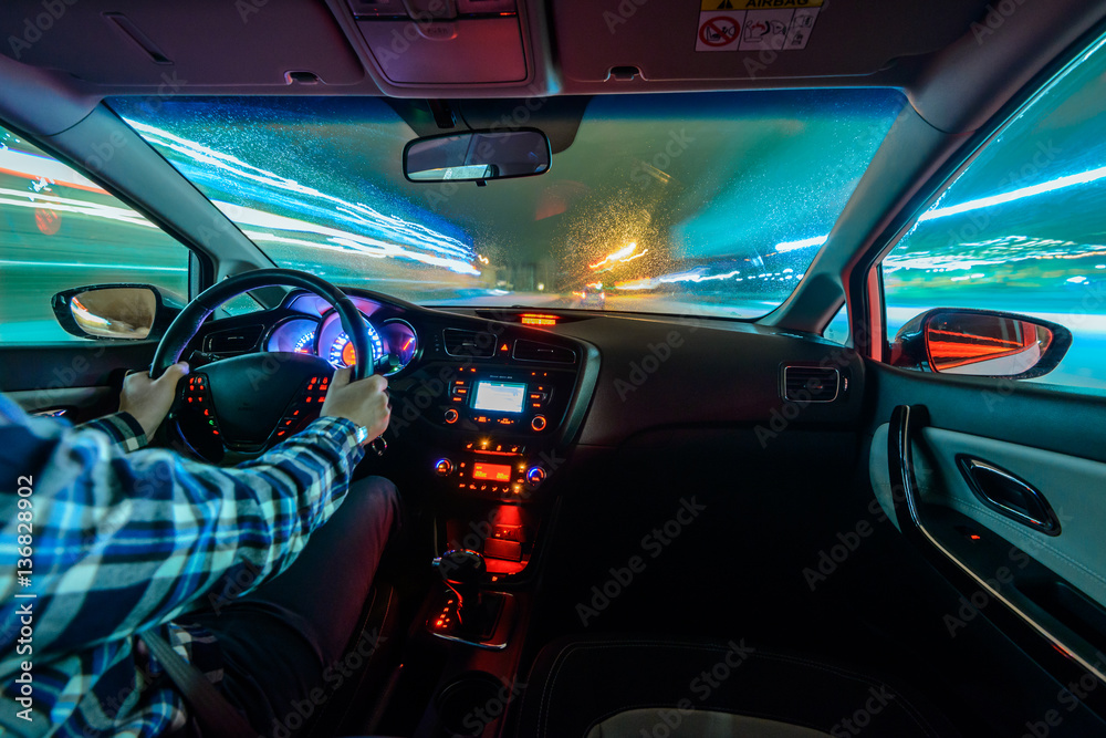 Fototapeta premium Jazda w nocnej scenerii, ręce na kierownicy.
