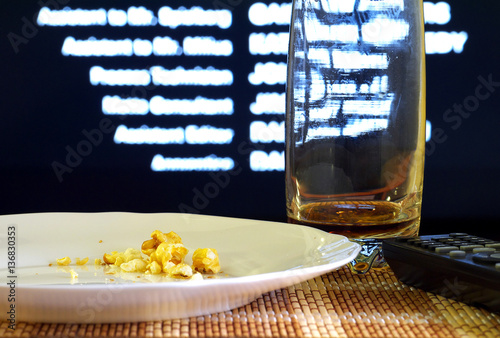 popcorn and coke leftovers and tv remote after watching movie,shallow depth of field