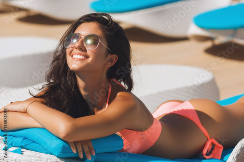 Beautiful girl on the beach relaxing, having a natural tan near the seaside photo