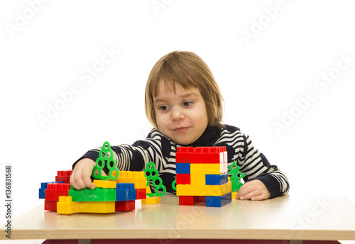 Little caucasian girl playing purposeful for children's table on