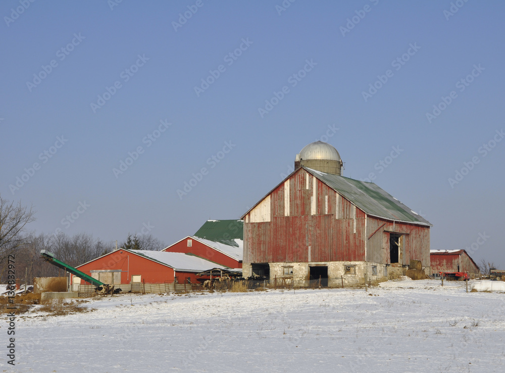 red agricultural barn with green roof in the Winter 