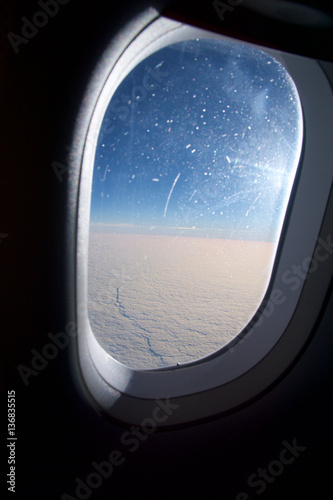 OSLO, NORWAY - JAN 21st, 2017: Closeup of the airplane window with the clouds sky background