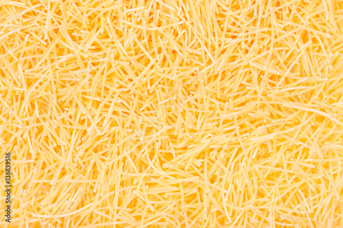 Pasta noodles background close up top view.