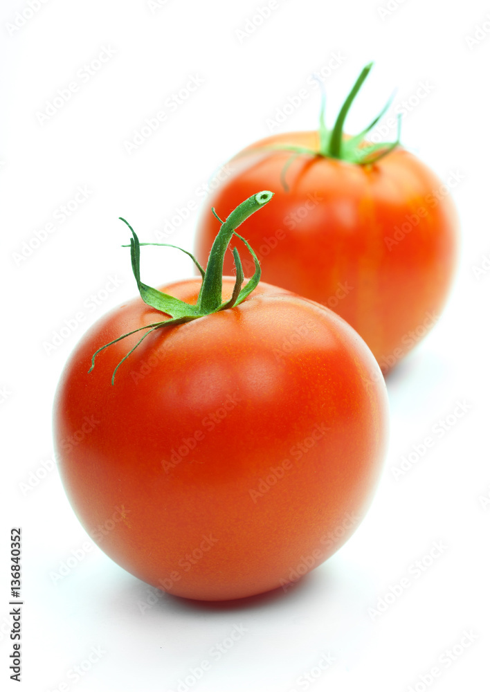 Two fresh tomatoes with green leaves isolated on white backgroun Two fresh tomatoes with green leaves isolated on white backgroun