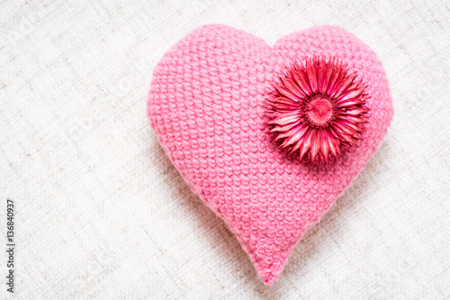 Knitted heart with dried flowers on a linen napkin