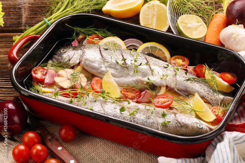 Raw trout with vegetables in a pan ready to bake