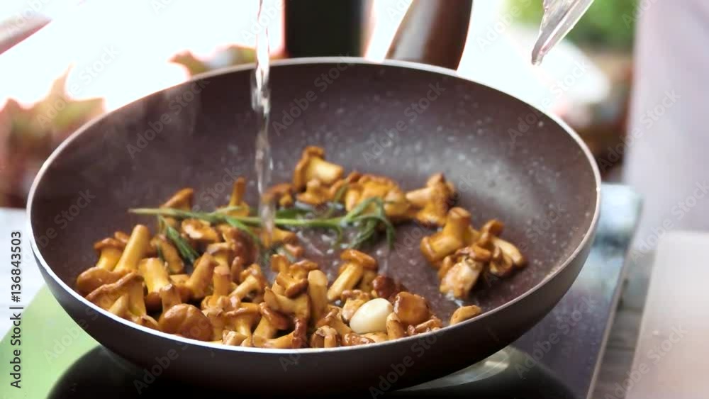 Water pouring in frying pan. Golden chanterelles and rosemary. Healthy recipes for dinner. Water pouring in frying pan. Golden chanterelles and rosemary. Healthy recipes for dinner.