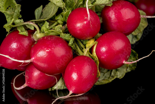 Many radishes with greens and stems