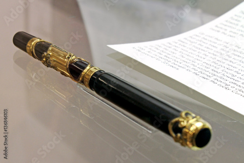 Antique gold business fountain pen lying next to an antique letter