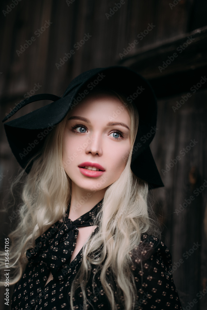 Beautiful attractive and stylish girl wearing black hat standing posing in city. Nude makeup, best daily hairstyle and great fashion glamour country style. Retouched photo Beautiful attractive and stylish girl wearing black hat standing posing in city. Nude makeup, best daily hairstyle and great fashion glamour country style. Retouched photo