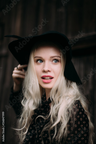 Beautiful attractive and stylish girl wearing black hat standing posing in city. Nude makeup, best daily hairstyle and great fashion glamour country style.