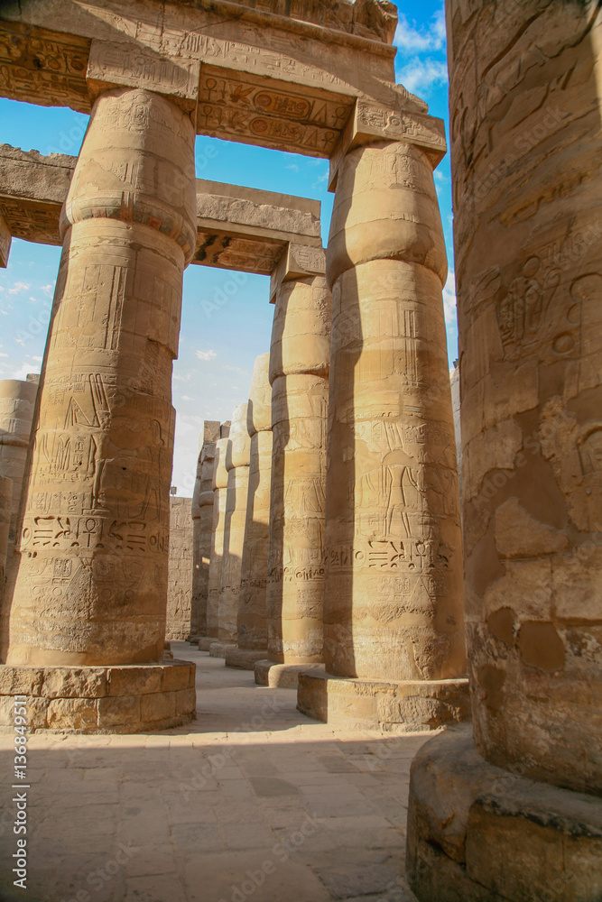 big stone columns with carving figures and hieroglyphs in landmark Egyptian Karnak Temple, public ancient monument declared a World Heritage by Unesco, in Luxor, Egypt, Africa
