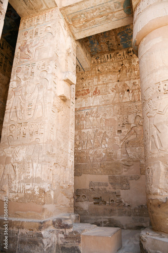 Egyptian paintings, carving figures and hieroglyphs in columns and wall of landmark Temple of Ramses or Ramesses III at Medinet Habu, monument in Luxor, Egypt, Africa
 photo