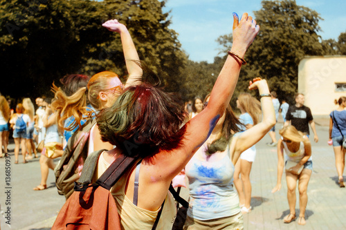 happy hipster girls having fun with colorful powder at holi fest