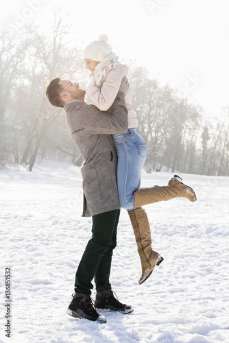 Smiling couple hugging and enjoying outdoors in winter