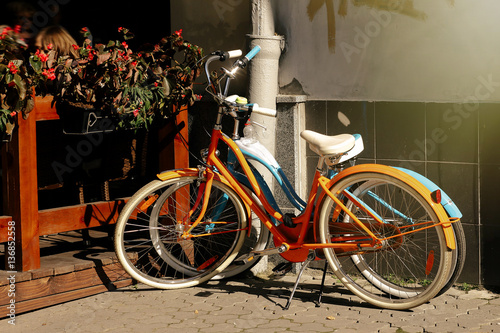 beautiful colorful bicycles parked at old sunny european street,