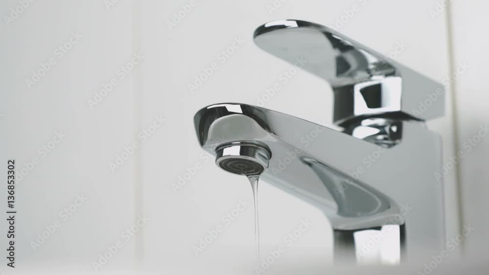 Bathroom. Water dripping from chrome-plated faucet. Close-up Bathroom. Water dripping from chrome-plated faucet. Close-up