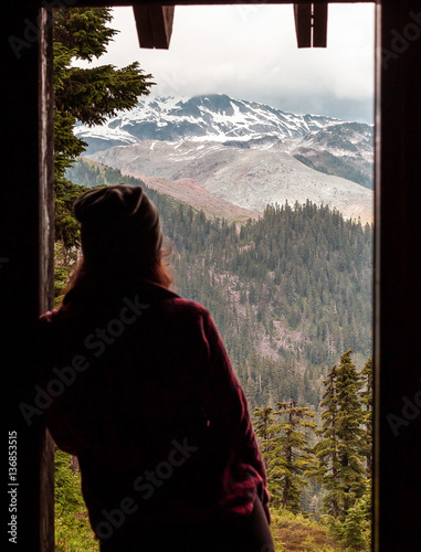 Person looking at view of snow capped mountains through doorway, Elfin Lakes, Canada, British Columbia, North America 