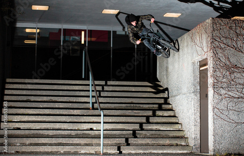 Man performing stunt on bike against wall 
