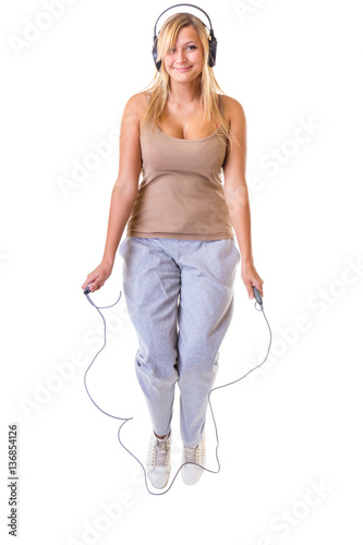 Happy blonde woman jumping on skipping rope
