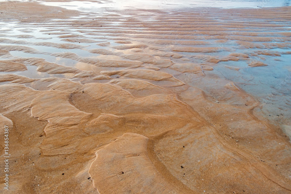 Fototapeta premium Nang Thong Beach at low tide in Khao Lak, Thailand. Seaside with sand dunes and reflection of blue sky in water. Natural background.