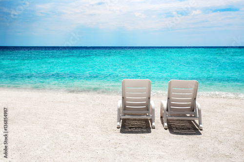 Two sun beds on white sand beach at tropical island © Ivan Kurmyshov