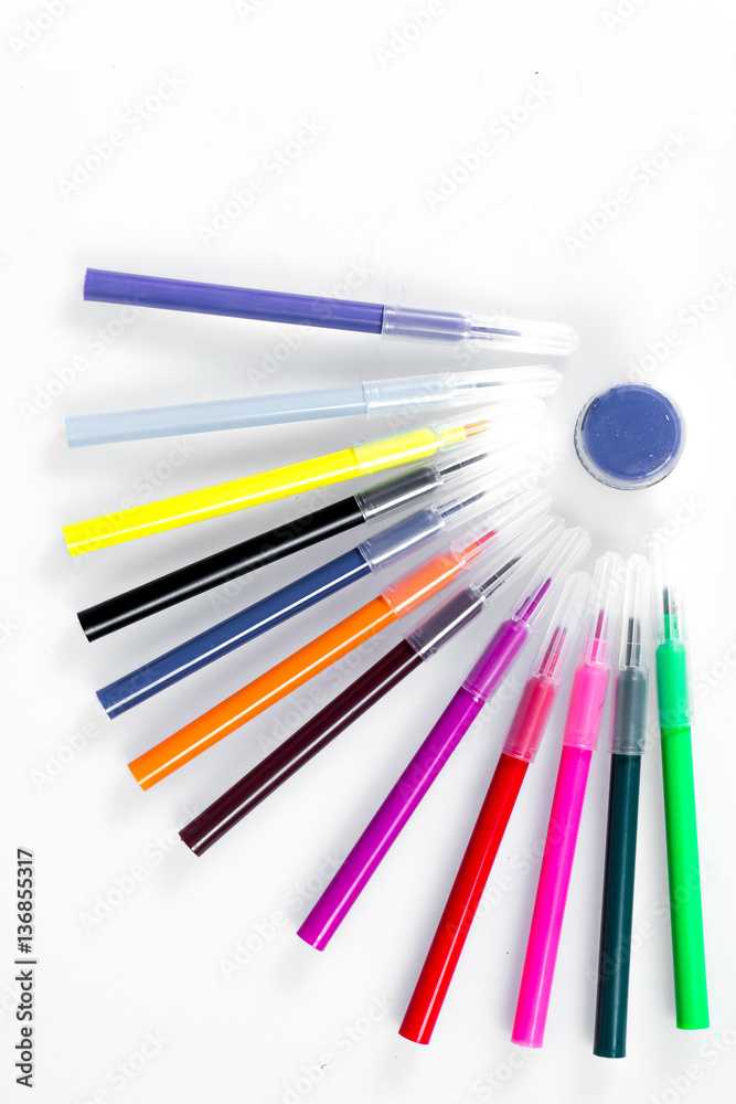 Colored markers laid out near the jars with paints like solar rays ...