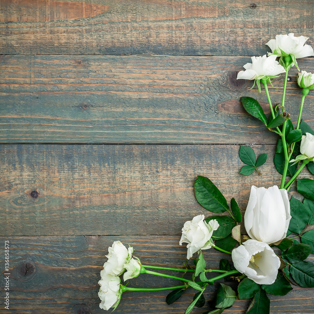 Floral background. Floral frame made white flowers and green leaves on wood background. Flat lay, top view. Floral background. Floral frame made white flowers and green leaves on wood background. Flat lay, top view.