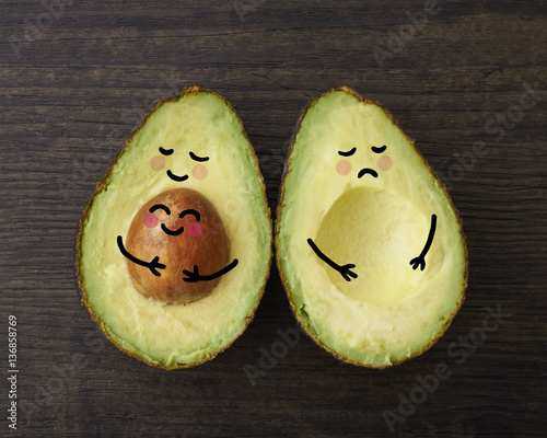 An avocado parent and child in embrace beside another avocado who is sad that is it without a child or baby