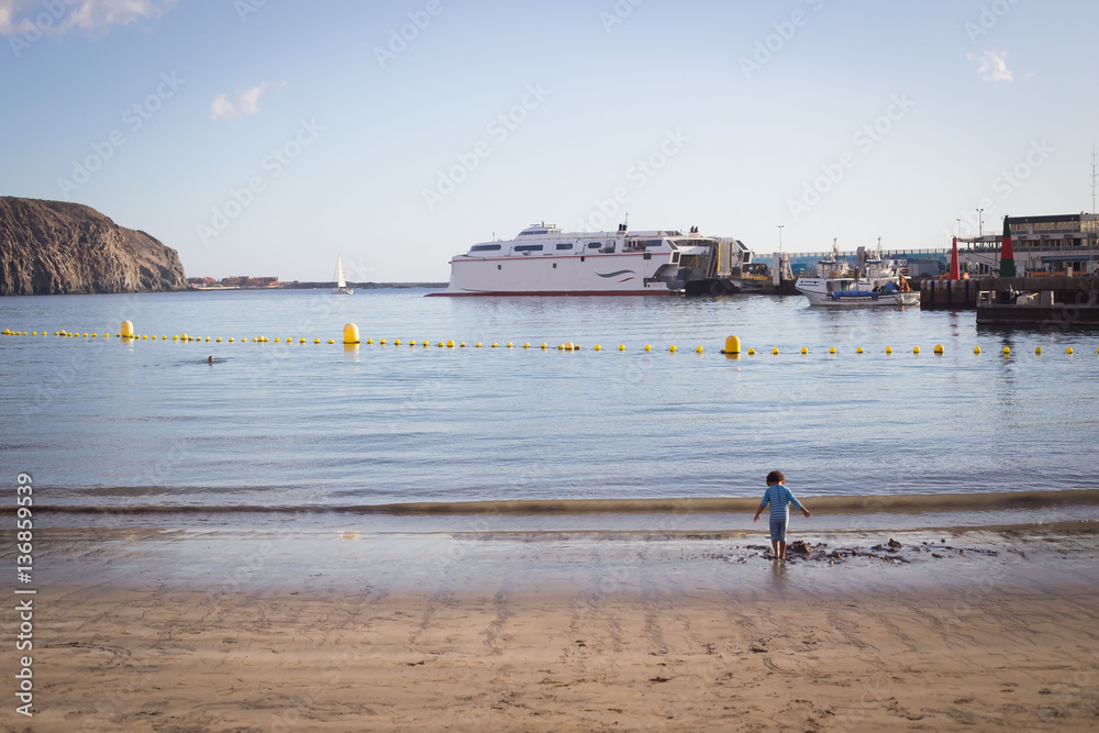 Tenerife beach with ferry and a kid