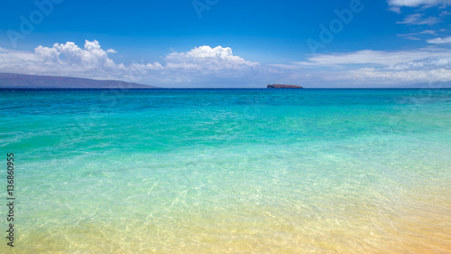 blue water at Makena Beach, Maui, Hawaii with Molokini crater at the horizon. Molokini is a crescent shaped island, the tip of an underwater volcano and a Snorkelling and diving destination 