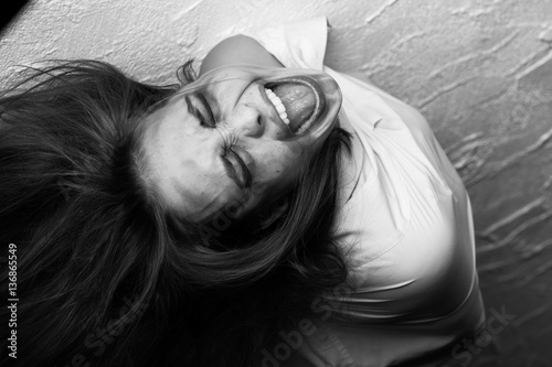 screaming crazy fun woman in straitjacket, monochrome photo