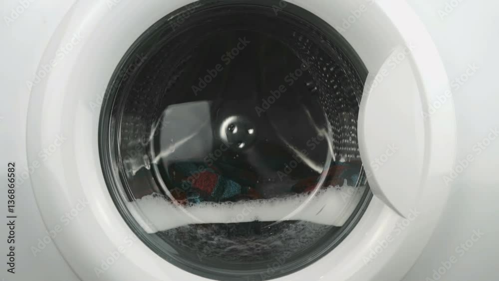 Home electronics. Internal view of a washing machine drum during wash program. Close-up Home electronics. Internal view of a washing machine drum during wash program. Close-up