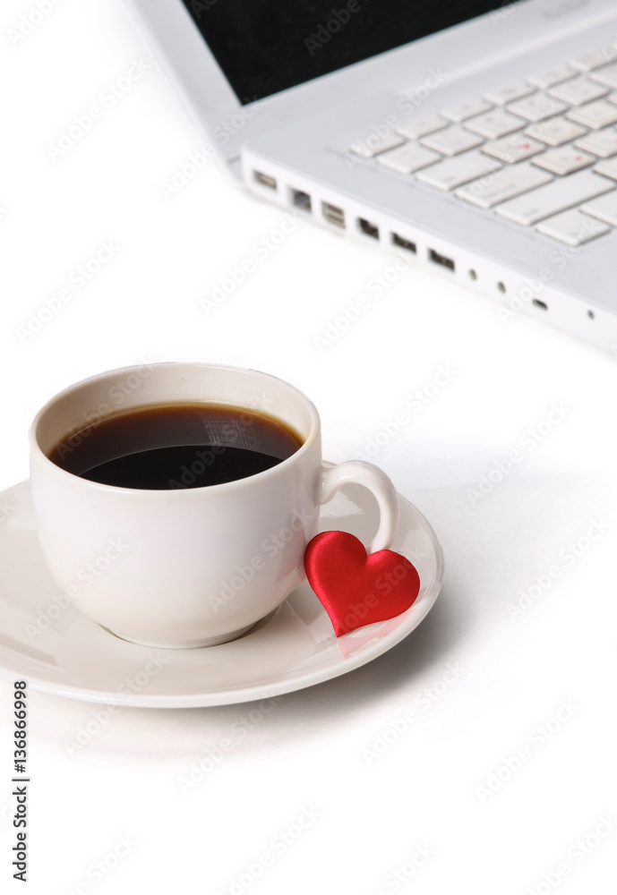 Laptop or notebook with cup of coffee and heart on table Laptop or notebook with cup of coffee and heart on table