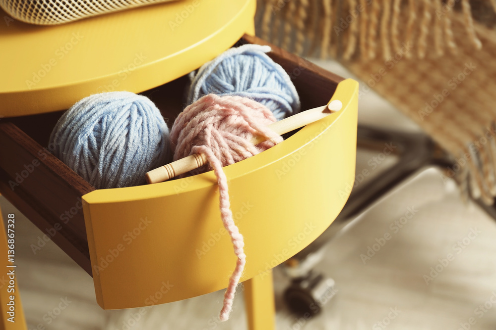 Fototapeta premium Knitting yarn and hook in yellow table drawer, closeup