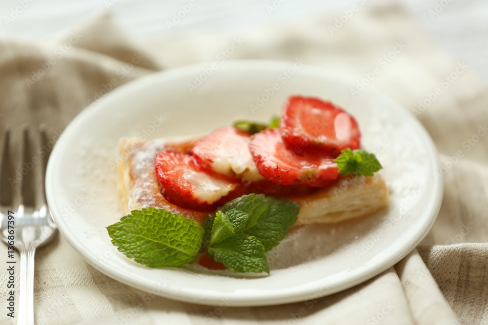 Sweet tasty pastry with strawberries on plate, closeup