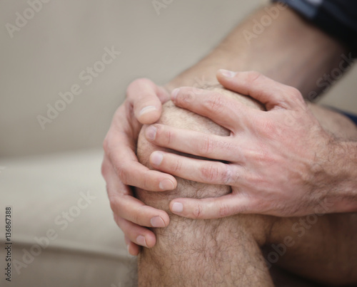 Man suffering from knee pain at home, closeup