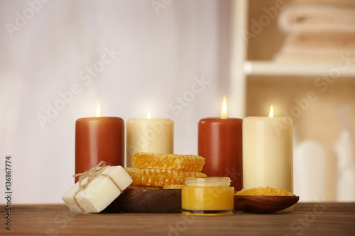 Spa concept. Beautiful composition of alight candles and natural honey treatments on wooden table